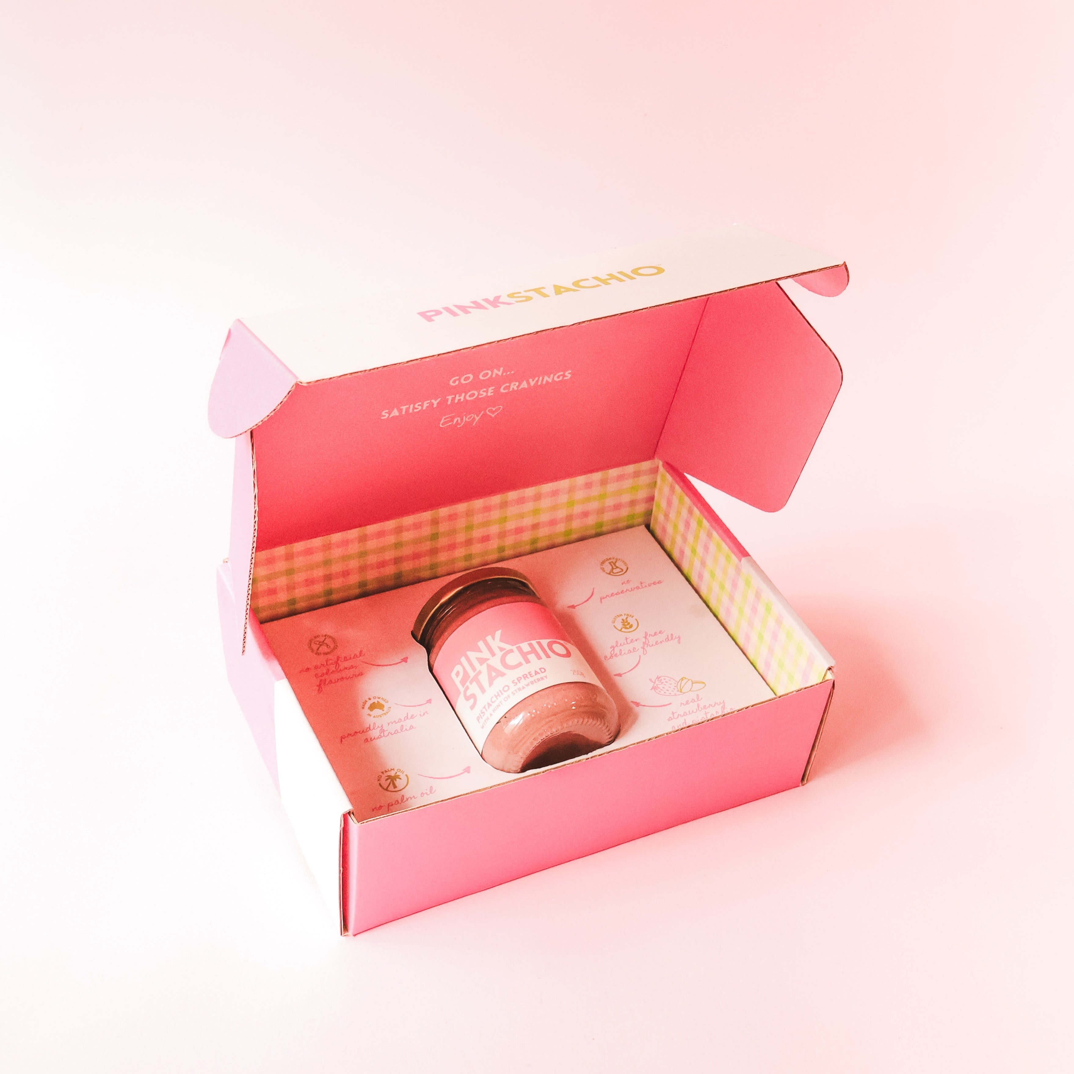 Pink gift box with a candle inside on a pink background