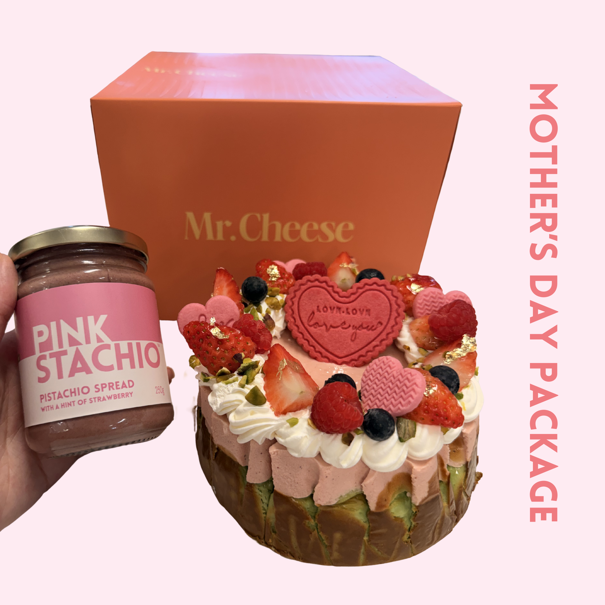 PinkStachio spread jar and decorated cake with 'Mr. Cheese' box on a pink background