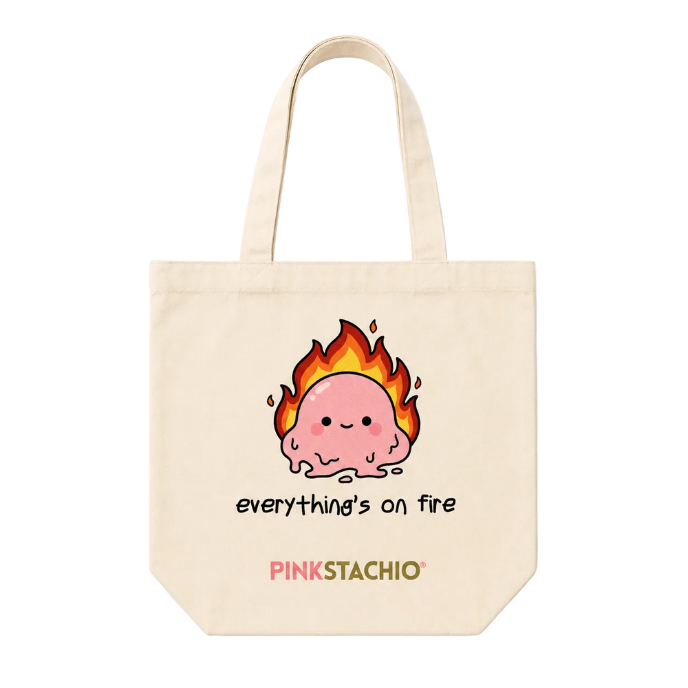 Tote bag with a cartoon character on fire and 'Pinkstachio' branding.